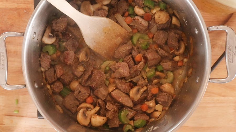 stirring stew with a spoon