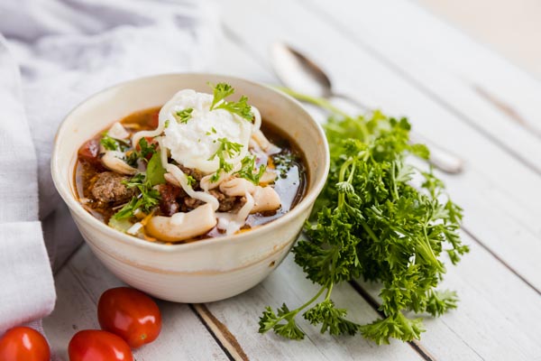 warm bowl of keto lasagna soup with parlsey and topped with ricotta cheese