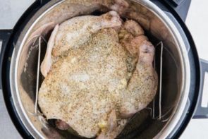 pouring lemon butter mixture underneath the chicken skin above the breast