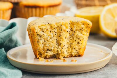 A half of a poppyseed muffin on a plate.