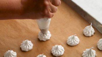 piping out small cookies with a star tip