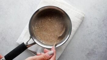 Stirring a saucepan with creamy oatmeal inside.