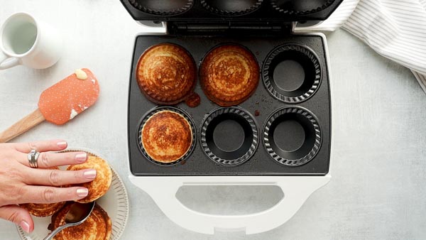 pulling out cooked pancake pies from the pie maker