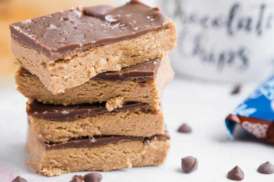 stack of chocolate topped bars with a few chips around