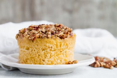 low carb pecan pie mug cake on a plate with pecan topping