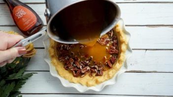 pouring pecan pie filling into pie crust