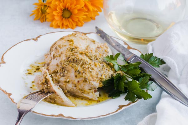 slicing pesto chicken on the dinner plate