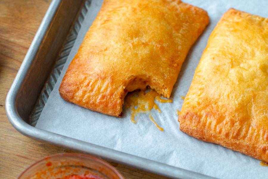 pepperoni pizza pocket with a bite taken out of it