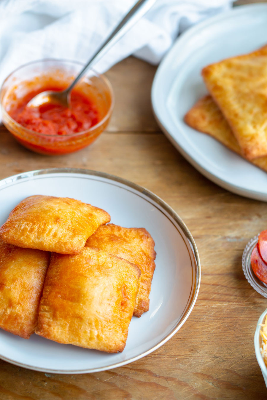 keto pizza pockets on a plate with keto marinara sauce in the background