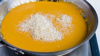 mixing in parmesan cheese to the low carb pumpkin sauce