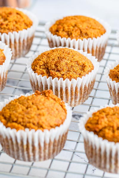 Baked pumpkin cupcakes cooling on a wire rack.