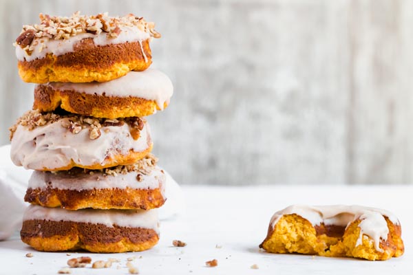 stack of pumpkin donuts with one eaten