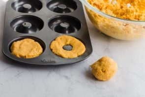 pumpkin donut dough in a donut baking pan