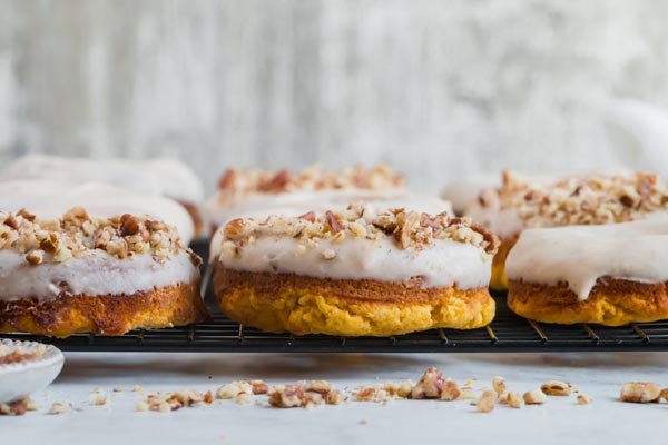 pecan topped keto pumpkin donuts on a wire rack