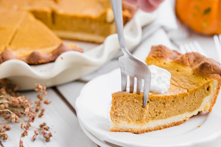 cutting a fork into a slice of pumpkin pie