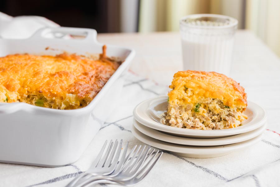 a large slice of breakfast casserole filled with sausage chunks and green onions