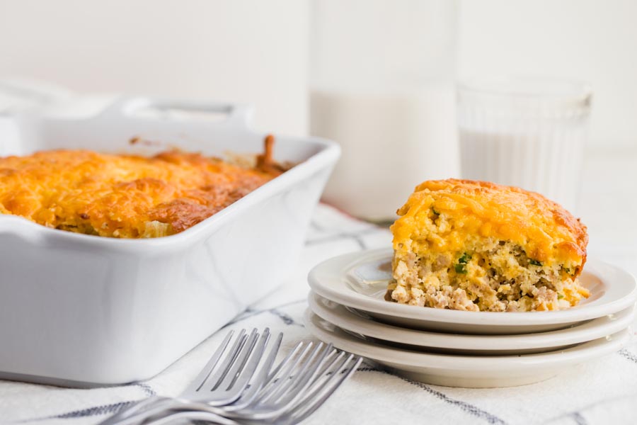 keto breakfast casserole on stacked plates with a glass of milk