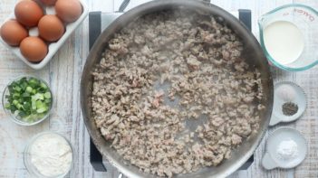 cooking ground sausage in a skillet next to other ingredients