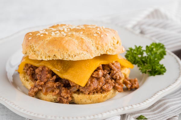 a sloppy jo burger on a plate with cheese