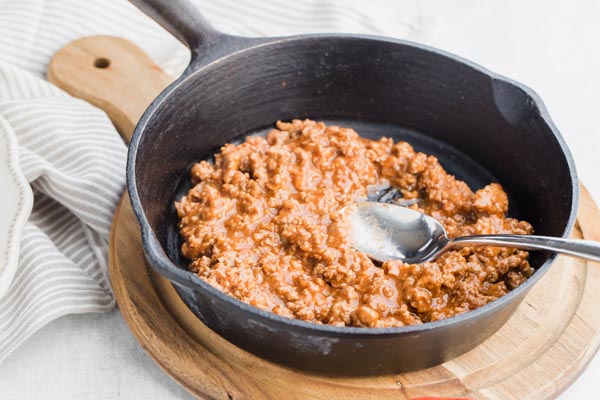 a cast iron skillet with sloppy joe mix in it