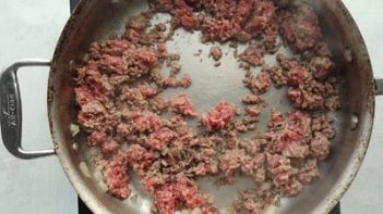 pink ground beef cooking in a skillet