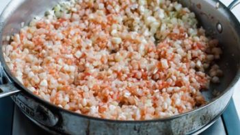 cauliflower rice mixed with tomato puree in a skillet