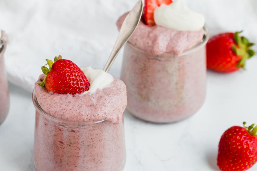 two keto chia puddings topped with whipped cream