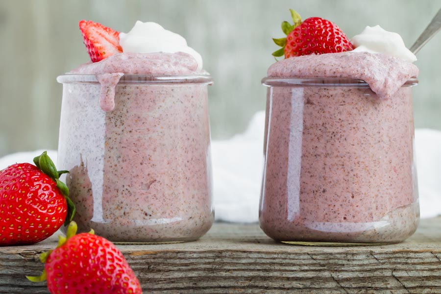 two containers of keto chia pudding on a wooden surface