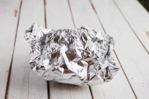 diced chicken thighs and cauliflower rice in the center of a sheet of aluminum foil