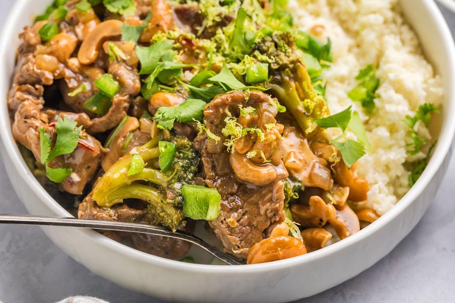 A bowl of low carb cashew beef with broccoli over coconut rice.