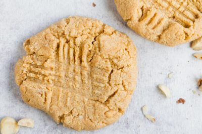 large peanut butter cookie on the counter with another one next to it