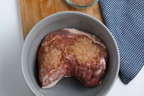 raw pork in a mixing bowl with dry rub on it