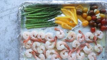 cooked shrimp and roasted vegetables on a baking tray