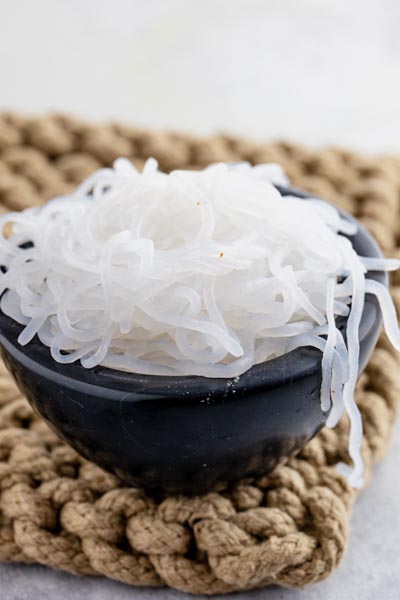 a bowl of white noodles on a hot pad