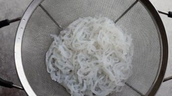 a strainer with white noodles inside