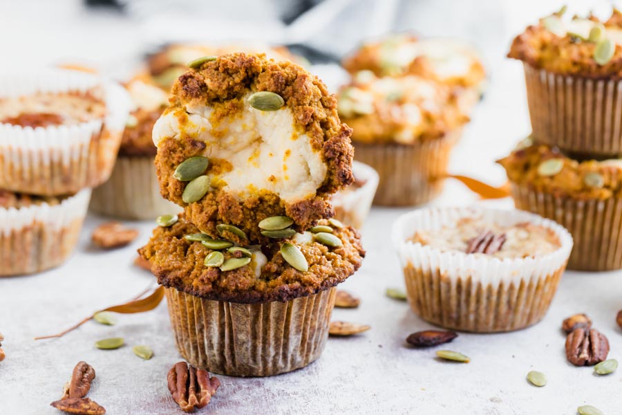 a stack of pumpkin muffins next to pecan muffins