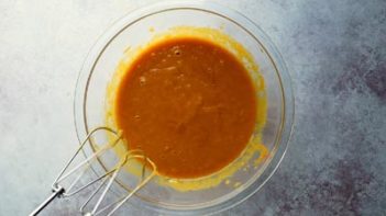 pumpkin wet mixture in a bowl with electric mixer below