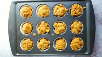 orange pumpkin batter in a muffin tin