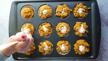 piping cream cheese in to pumpkin muffin batter