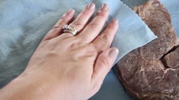 patting beef steak with paper towels